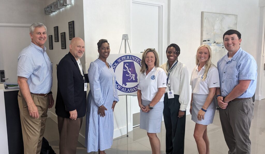 Day of AI speakers pose with SSA organizers before the organization logo.
